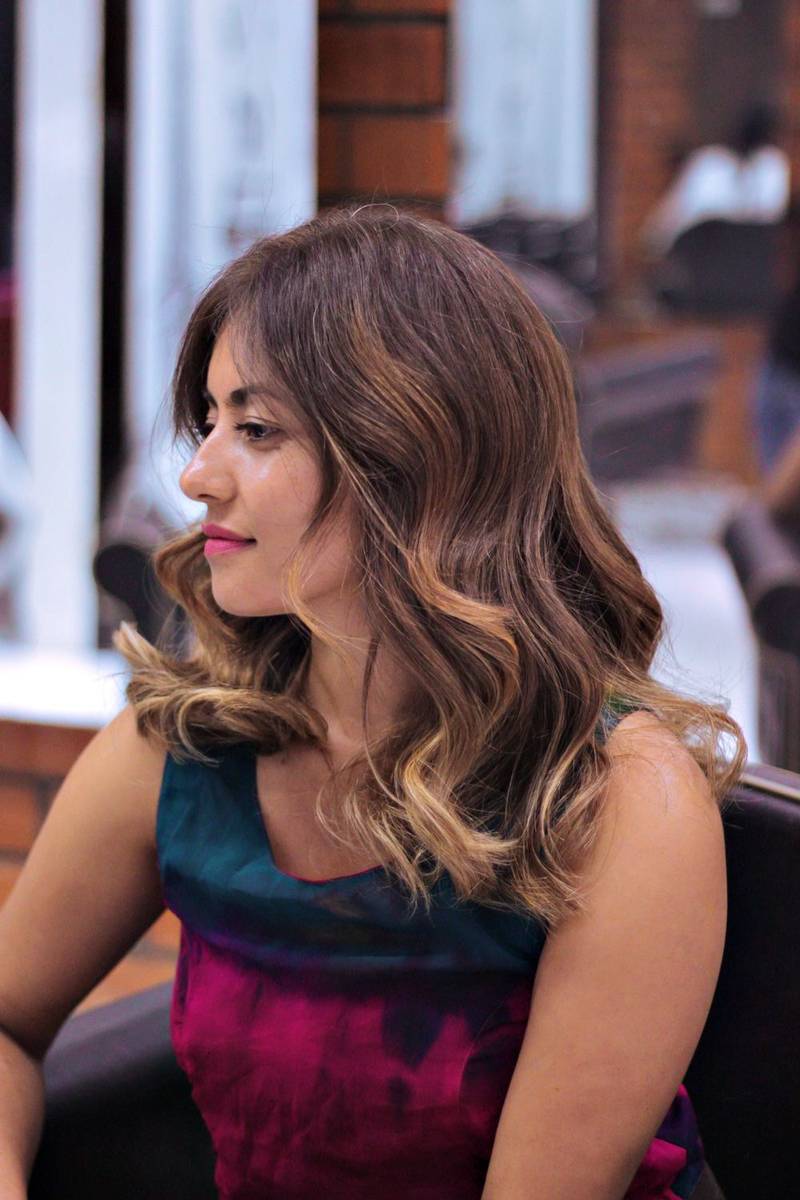 Dark hair with caramel balayage in a salon chair